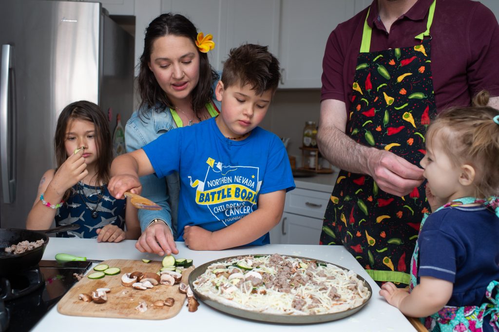 Family making pizza together and eating